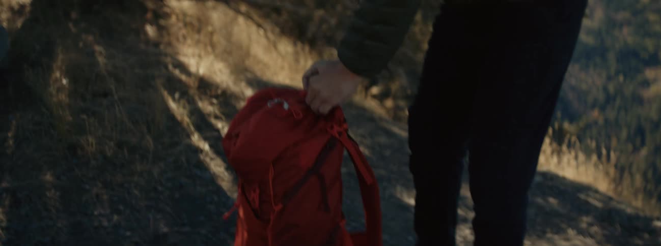 A man takes off his backpack and looks through it