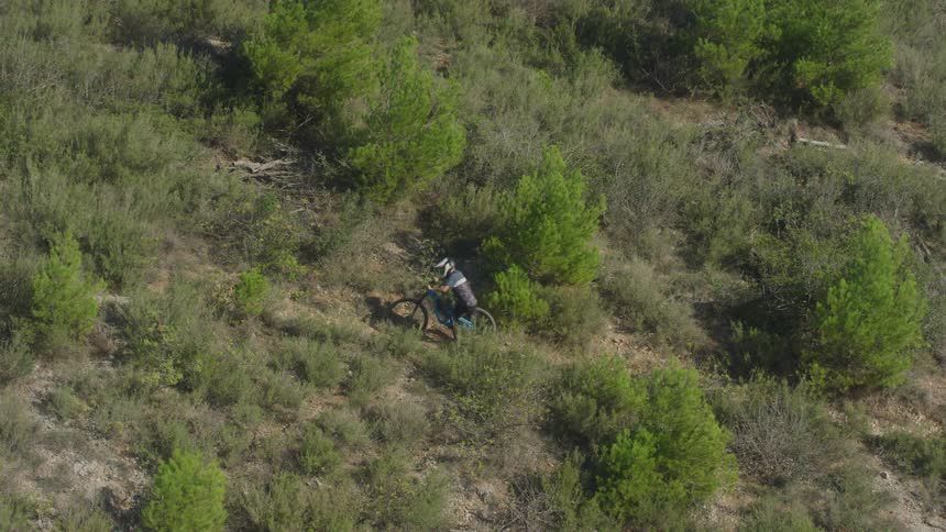 A man is pushing his bike uphill