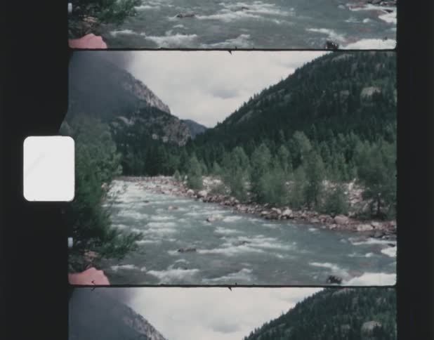 The river runs through the mountains on a cloudy day