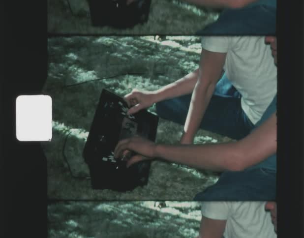 Two teenage boys are playing vintage computer games using a console while sitting on the ground