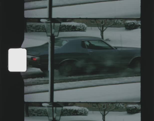 An automobile slides as it turns on to a snow covered road on a winter day