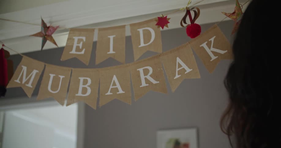 A woman hangs decorations for a party