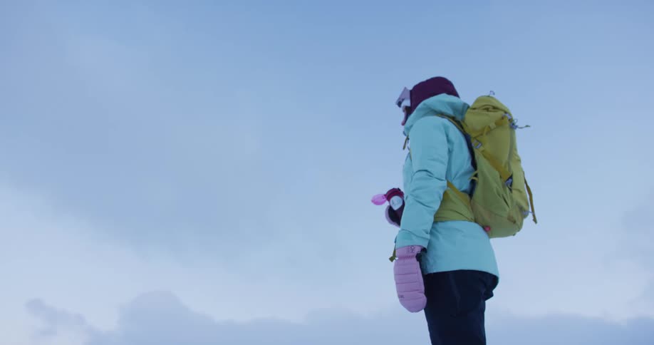 A hiker takes a drink on a windy day
