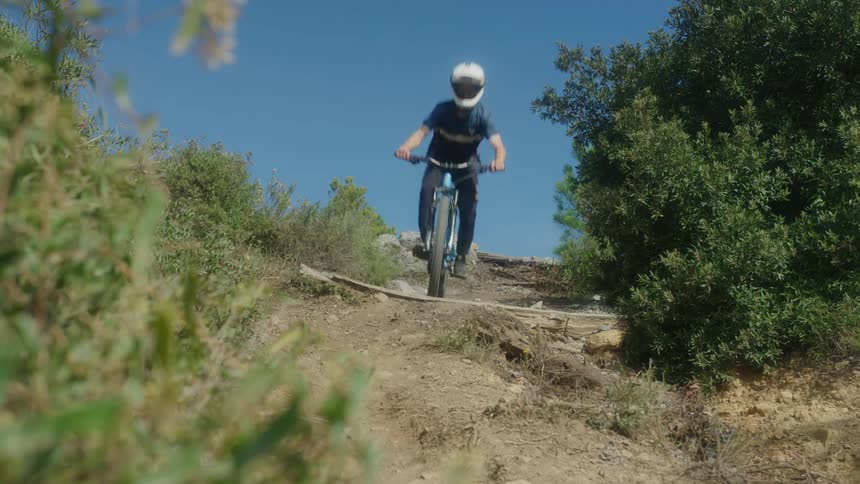 A person riding a mountain bike down some jumps