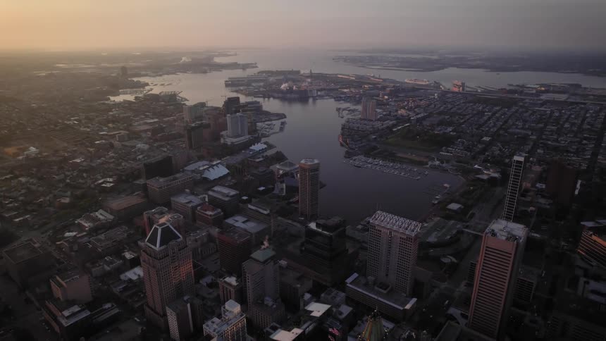 The sun is rising on the city inner harbor of Baltimore