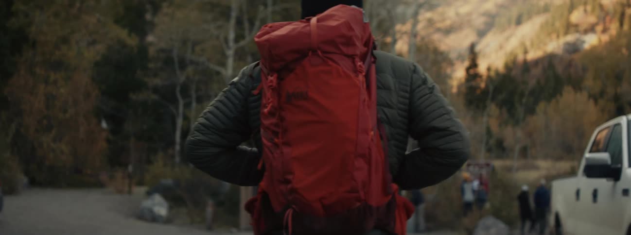 A man is hiking outdoors in a wooded area