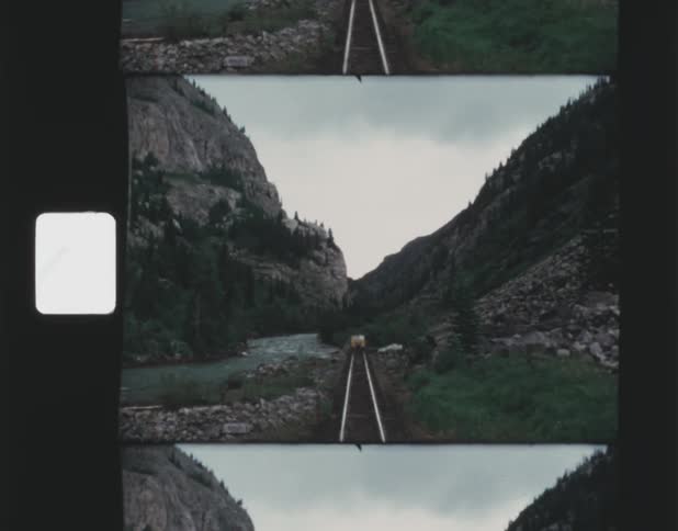 Train tracks run through the valley of a canyon