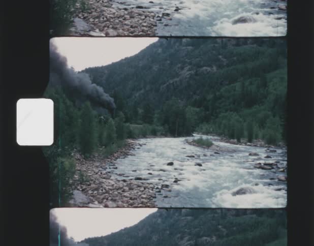Dark smoke rising from a forest fire next to a river