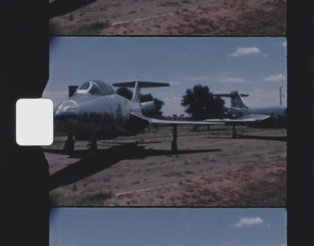A view of a lot of planes out in a field