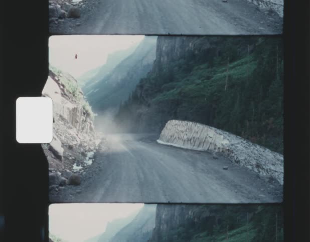 A dirt road is passing its way through a mountainous area