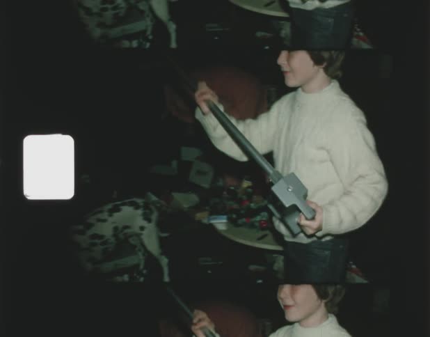 A boy pulls a device from a pile on the floor
