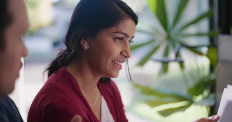 Businesswoman listens to businessman and nods approvingly at the office