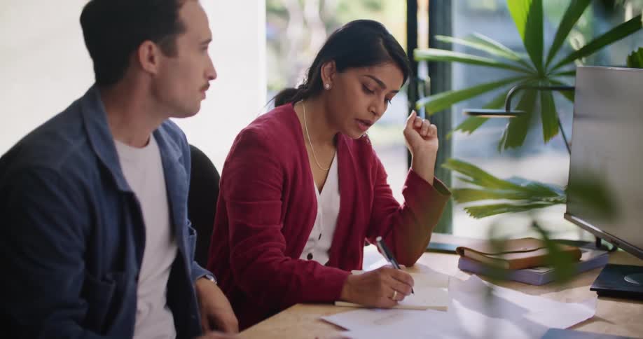 A man and woman discuss information that theyre looking at on a computer screen