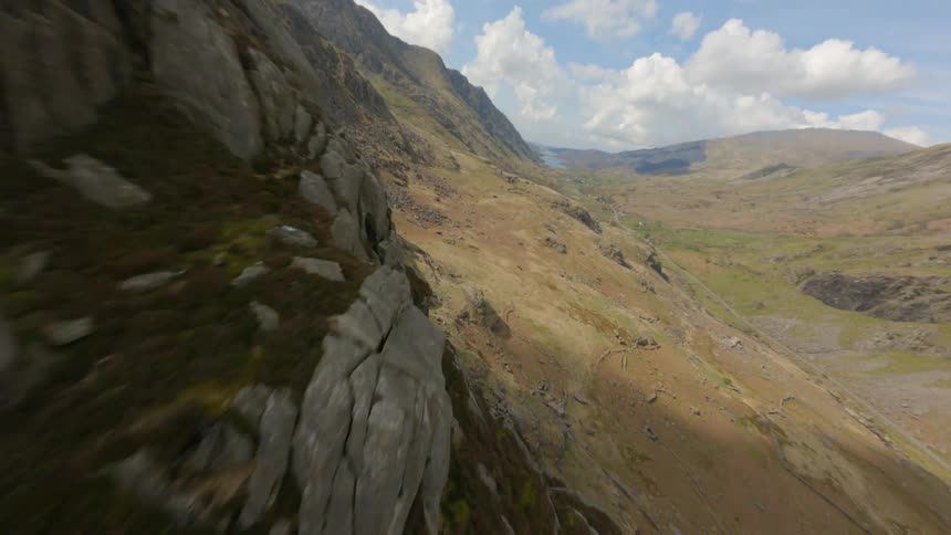 An aerial view from above shows several mountains with dirt and mud on them as well as moss and rocks
