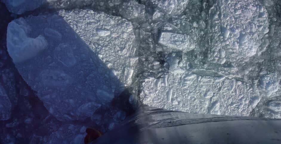 A boat cutting through chunks of ice