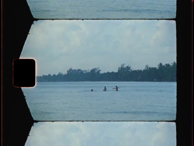 Three men swimming in water