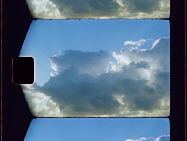 Cumulus clouds flow across sunny blue sky
