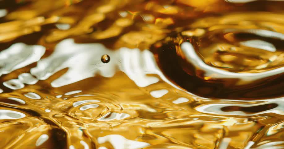 Droplets fall into and combine with a gold liquid