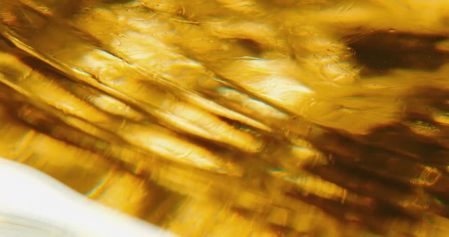 A close up of a yellow beverage with ripples across the surface