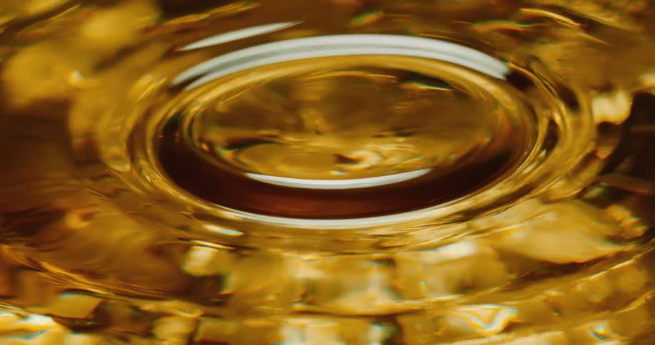 A drop falls in the gold water