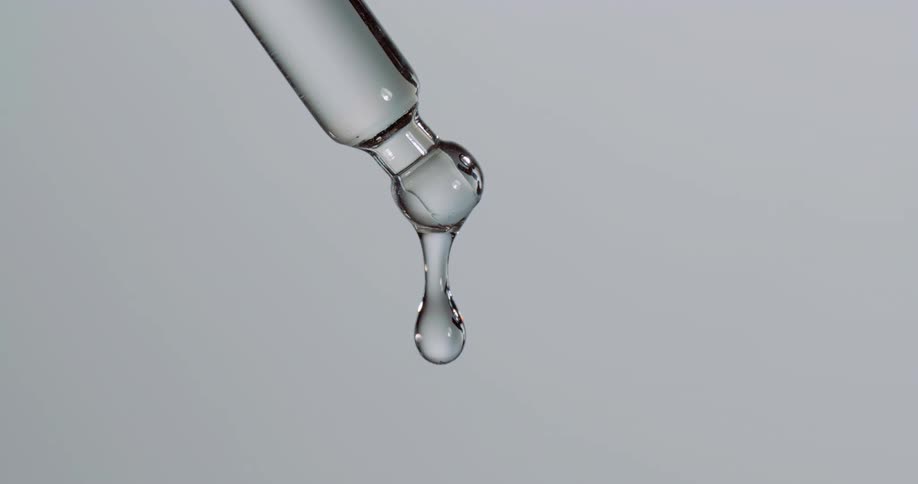 A drop falls from the glass vial