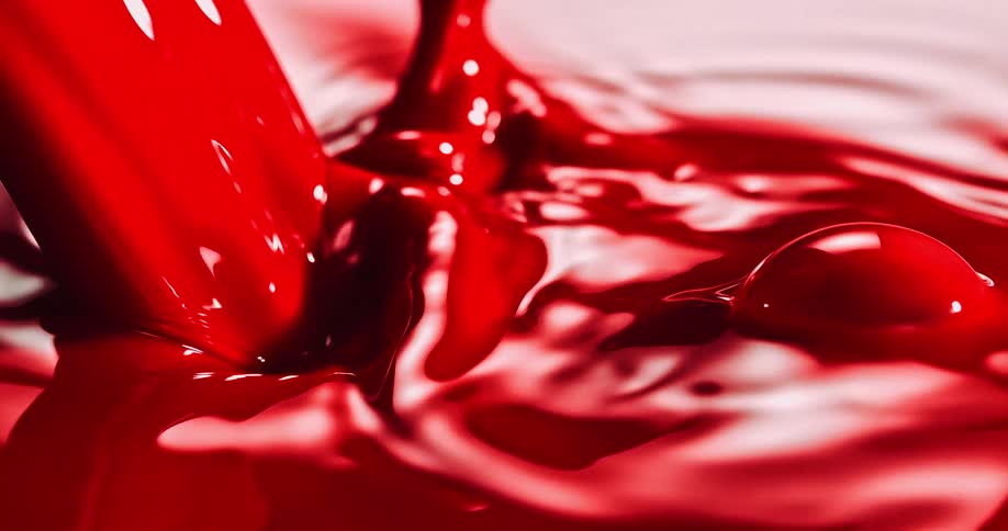 Ripples and drops around pouring red paint