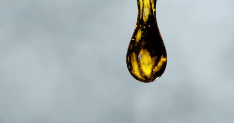 A gold drop of liquid falls