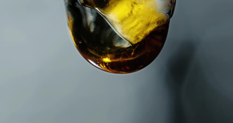 A yellow substance moves across the surface of an object as it becomes covered in a thick golden liquid that is ready to drip