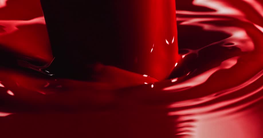 A thick red liquid pours across a puddle rippling and splashing as it moves
