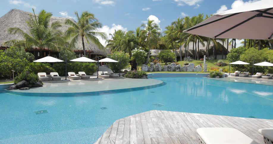 A pool is surrounded by huts