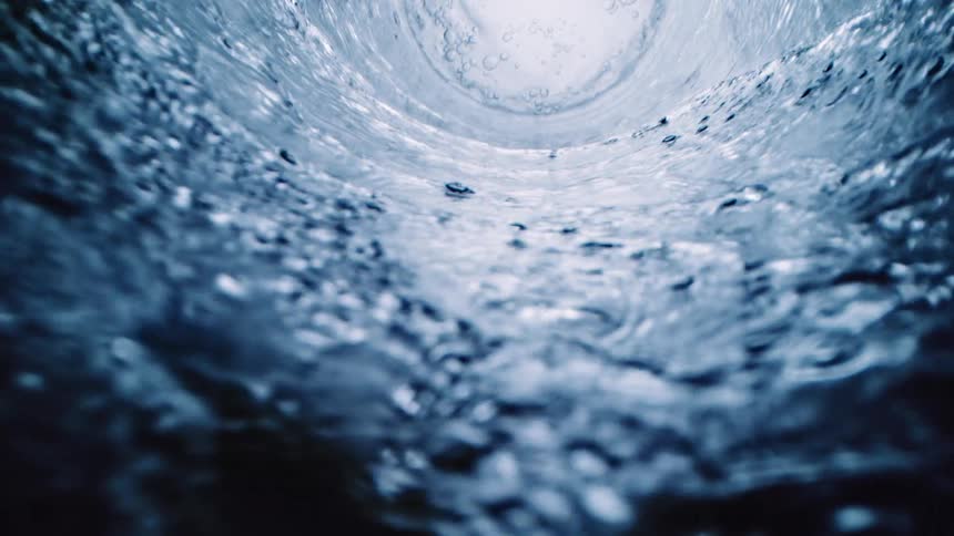 Water flowing in a spiral down a pipe where its pooled at the bottom