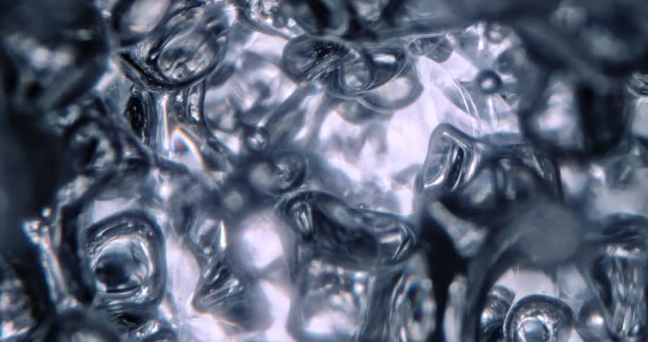 Light shines on clear liquid shapes moving and stretching