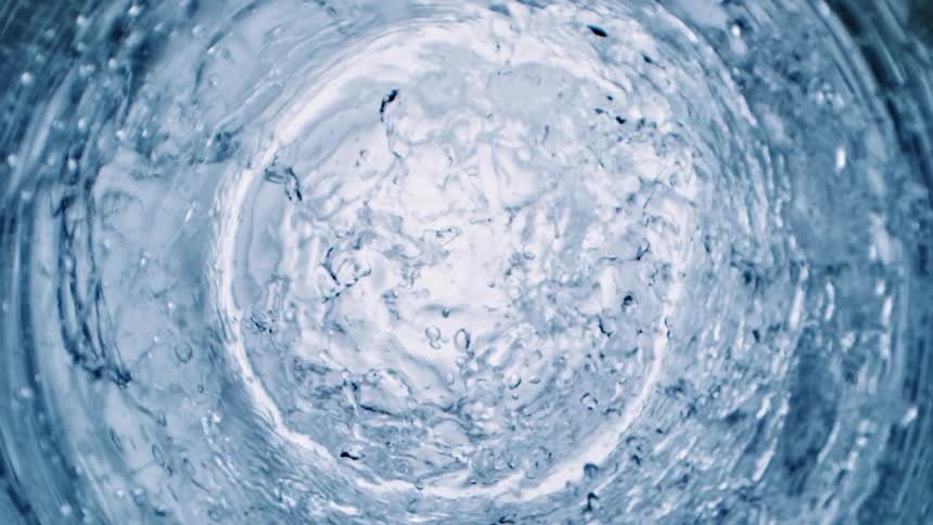 Rings of white circles are sitting on the surface as they sink underwater bubbles rise in the ripples as the water moves