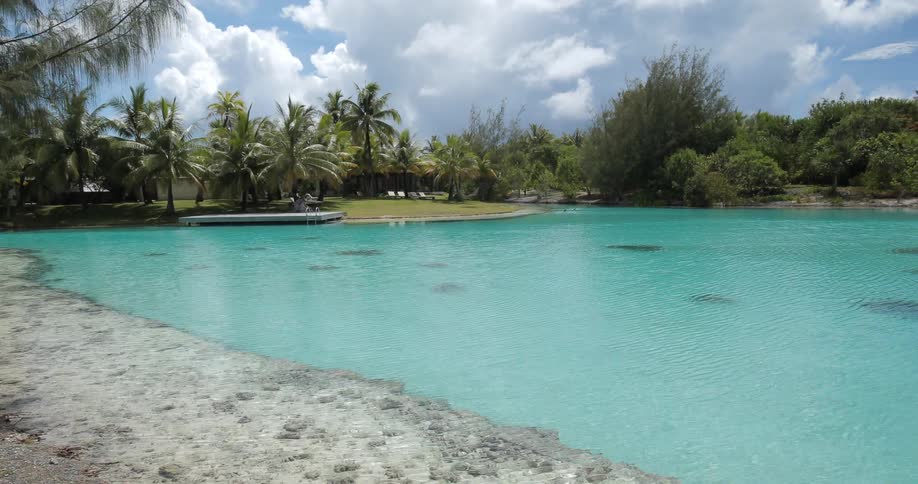 The water surrounding a tropical resort is bright blue-green