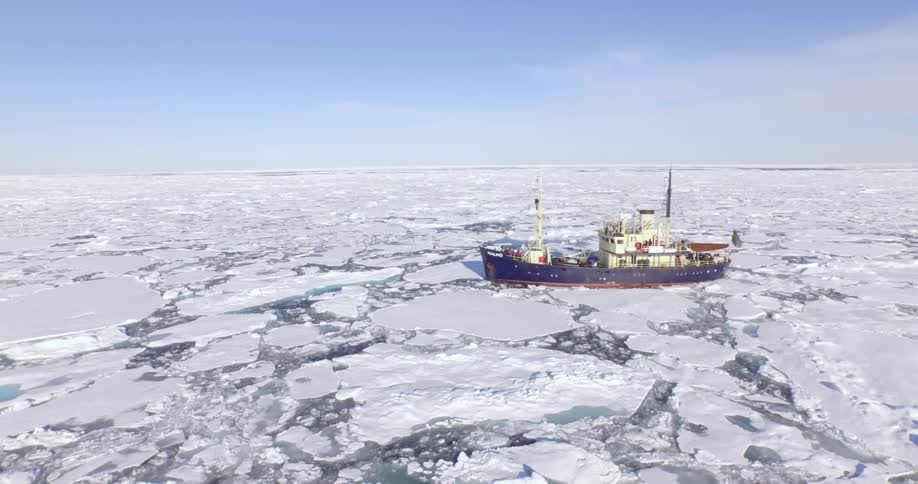 A boat stranded among many glaciers in the ocean