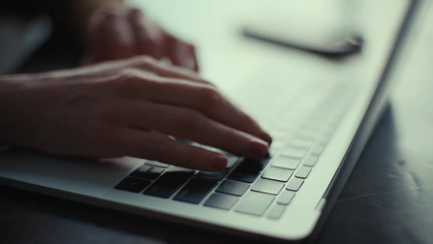 A person is typing on the laptop