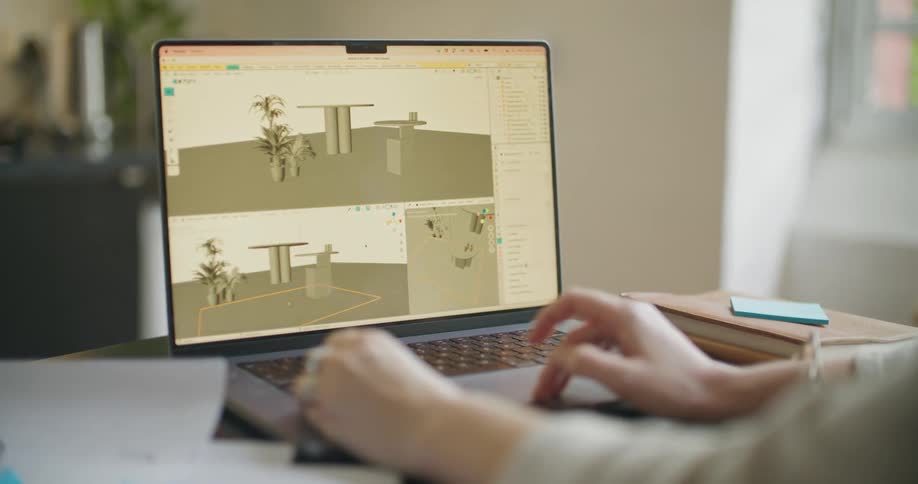 A woman uses a 3d rendering program on her laptop