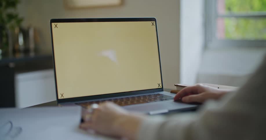 A persons hands are on a laptop computer as they look at a blank screen