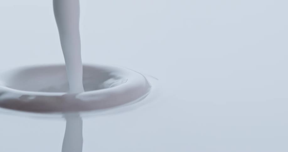 Close up of white paint being poured into liquid