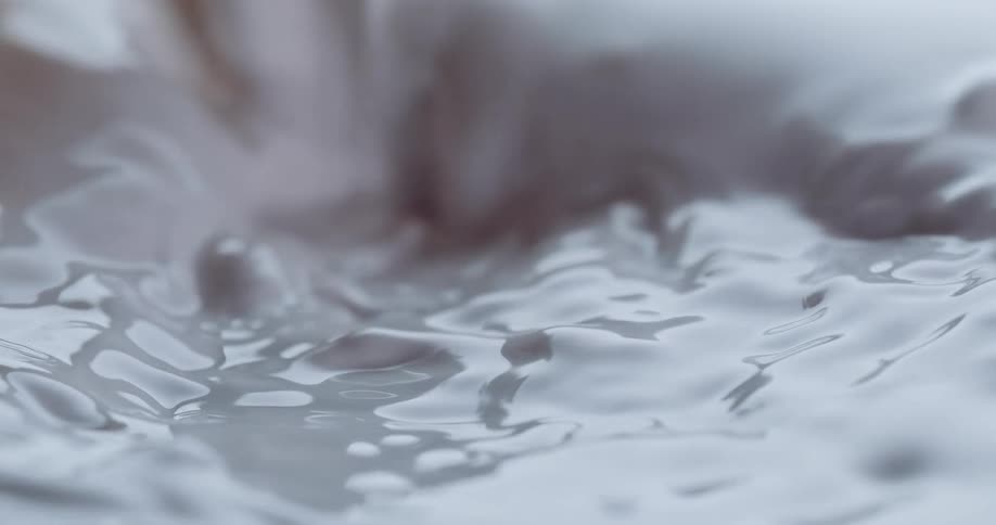 Milky white liquid being poured into itself creating waves and ripples