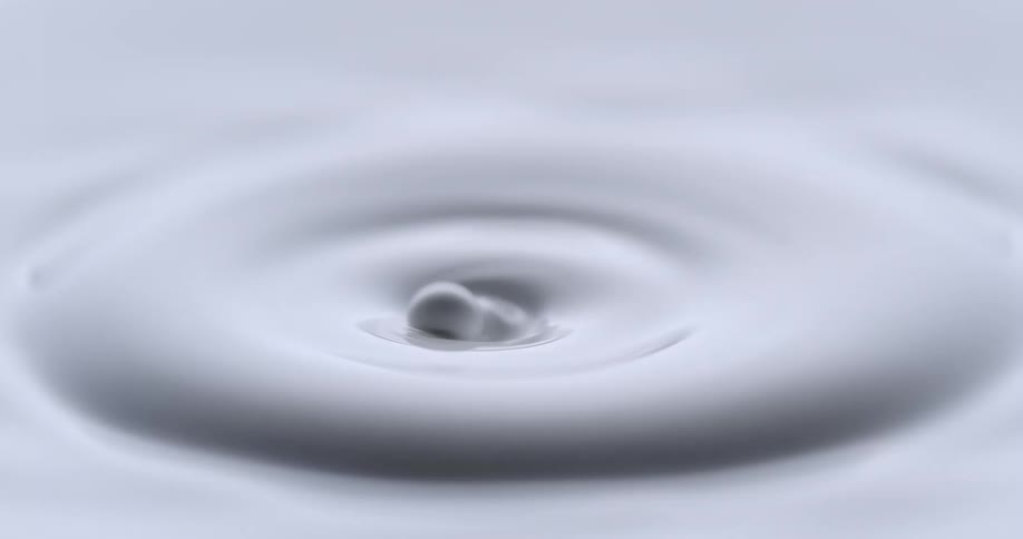 White droplet falls into white paint and spread across on the surface