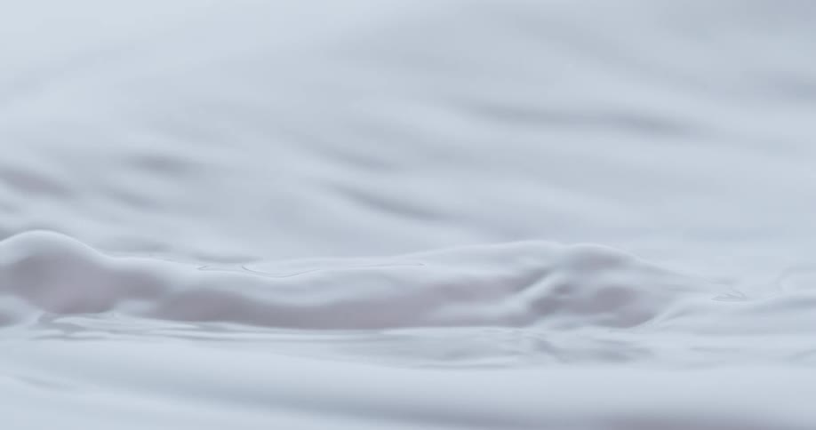 Milk splashes into a large container of milk