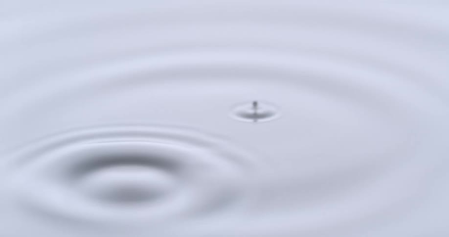 White water droplet falls into white paint