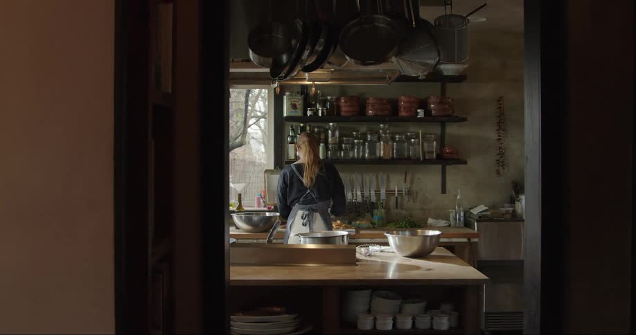 A woman is cooking in a restaurant kitchen