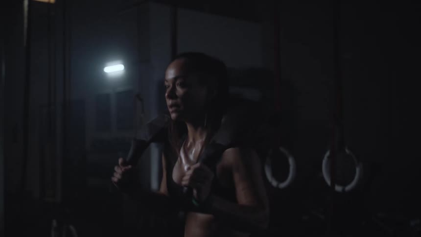 A woman working out doing squats in a dark room