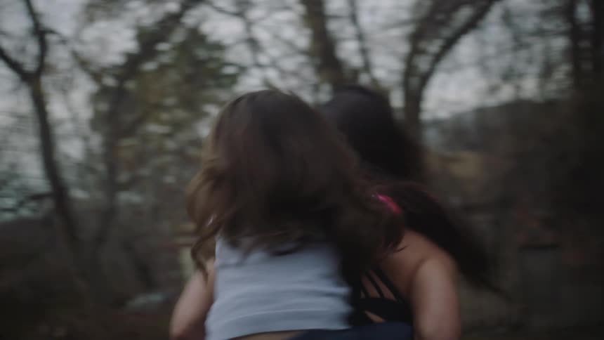 Mother and daughter laugh as mother spins with daughter riding piggyback