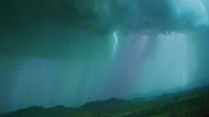 Lightning flashes and strikes a green slope during a thunder storm