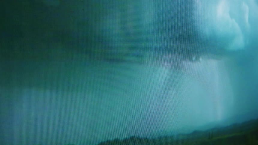 Close up of television screen showing hurricane and lightnings
