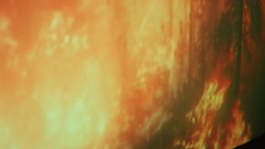 Close up of television screen showing forest fire