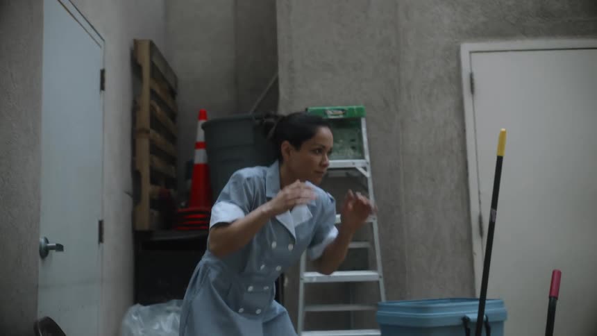 A woman dressed as a maid practices her wrestling moves in a supply area
